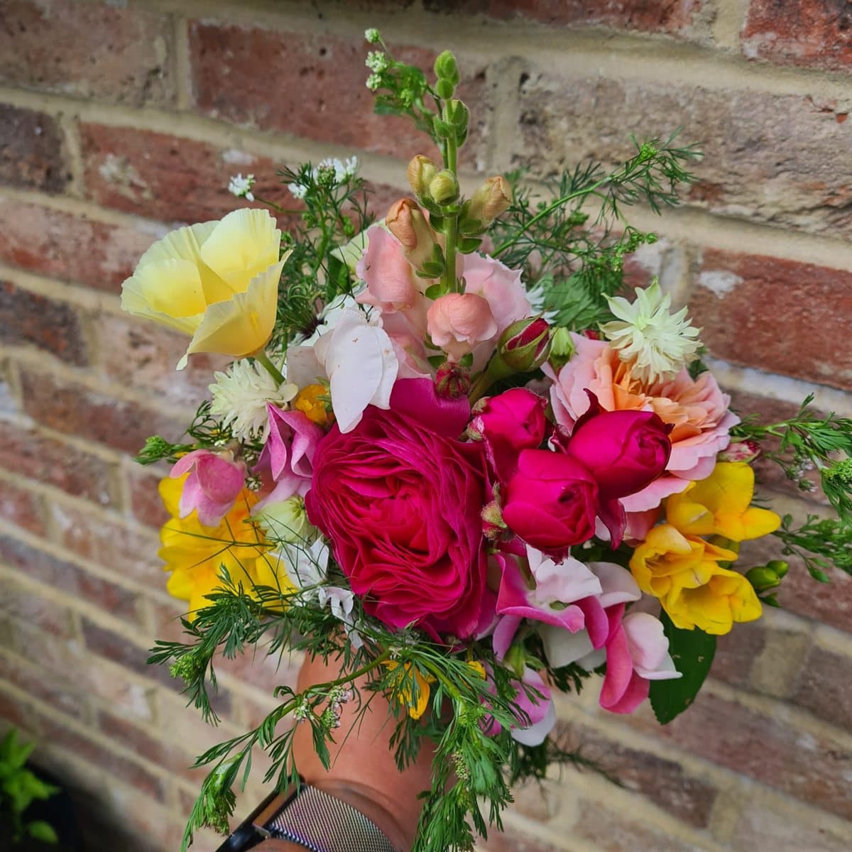 A bright wildflower bouquet of roses, freesia and dahlias