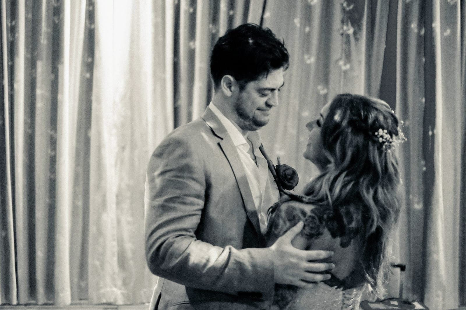 Newlyweds sharing their first dance, foreheads almost touching
