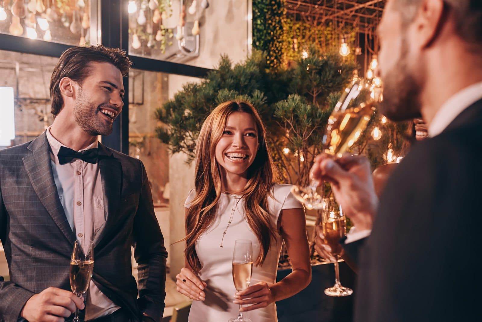 A couple laughing together with champagne at a black-tie celebration